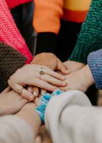 Hands on top of each other in a circle in unity